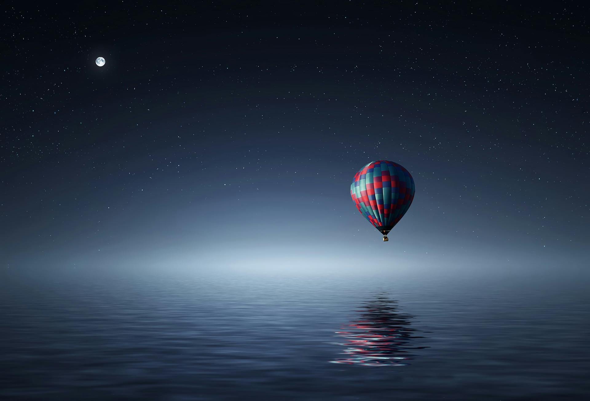 Hot air balloon over calm ocean